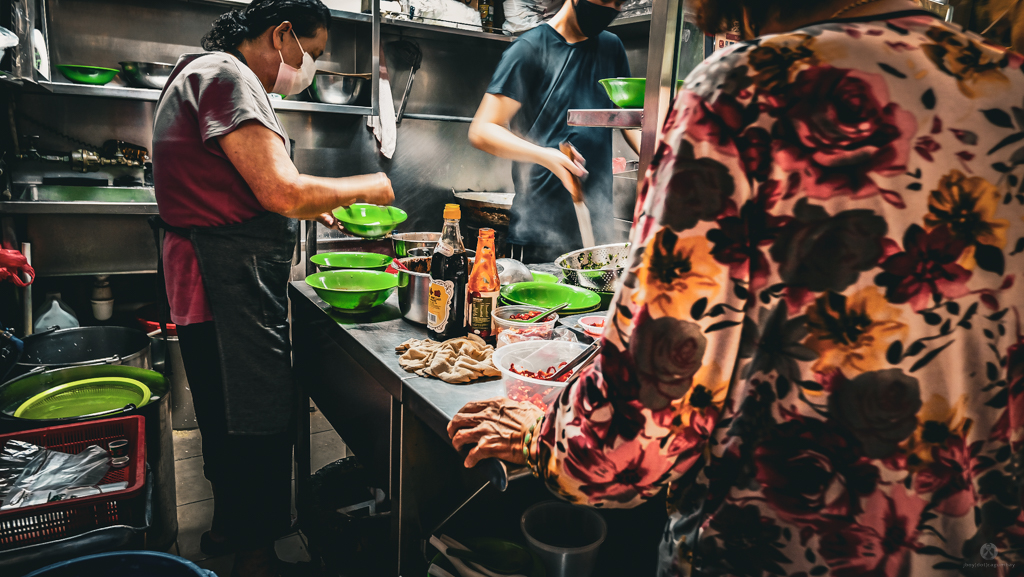 Patiently waiting in line at the noodle hawker stall